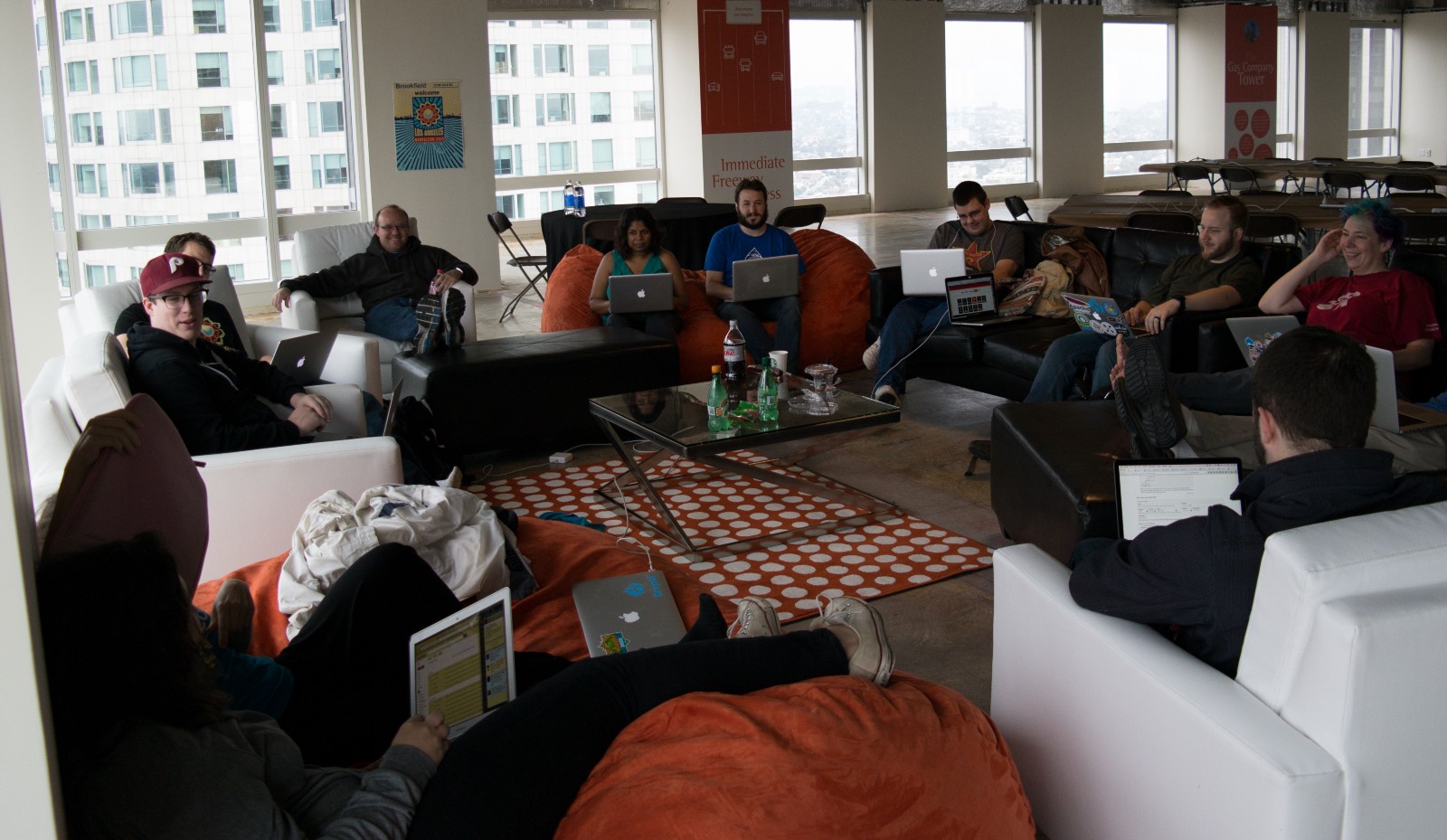 Photo of people sitting in a circle working on their laptops